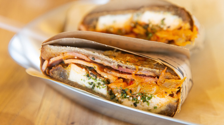 Close up of a chicken and kimchi sandwich on a tray