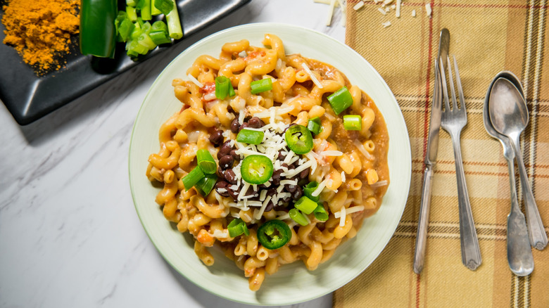 Overhead view of plate of mac and cheese with jalapeños and taco seasoning