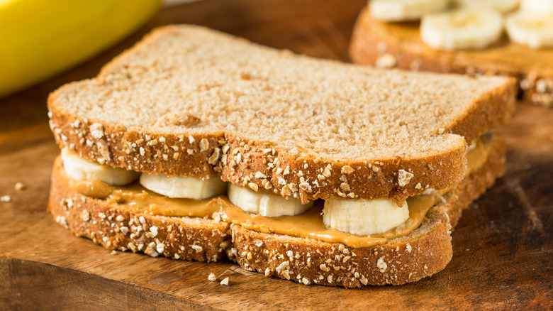 Peanut butter and banana sandwich on wooden cutting board