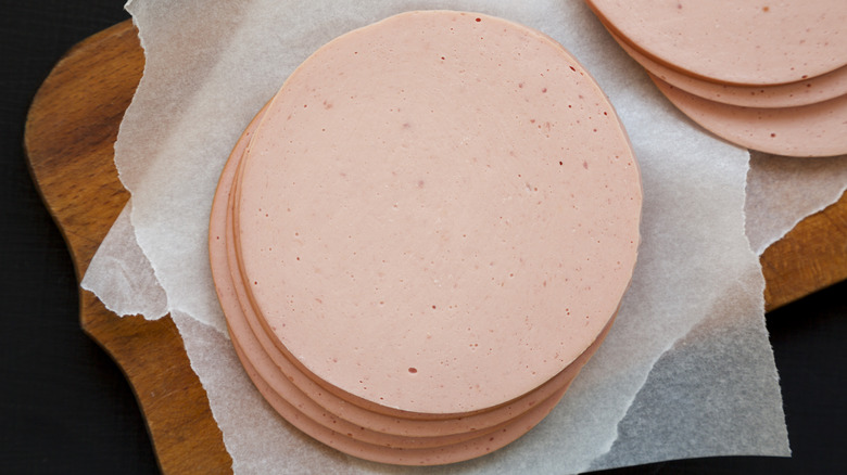 Slices of bologna meat on white parchment paper
