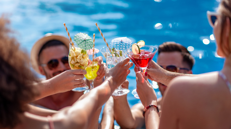 friends enjoy cocktails by the pool 