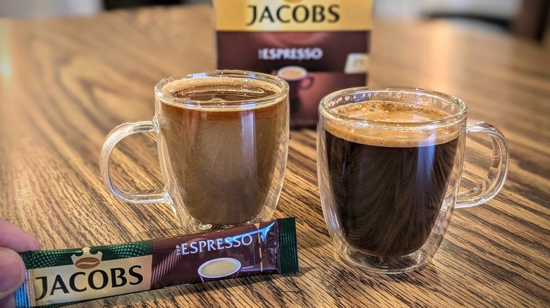 Two espresso cups and packet of instant espresso with Jacobs box in background