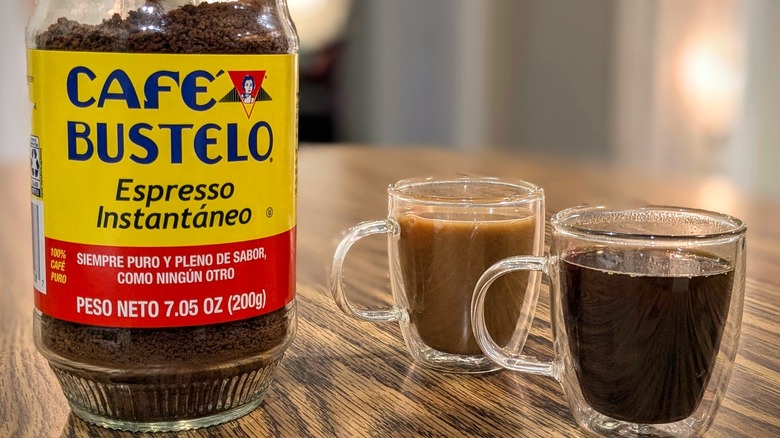 Café Bustelo jar and two espresso cups on wood table