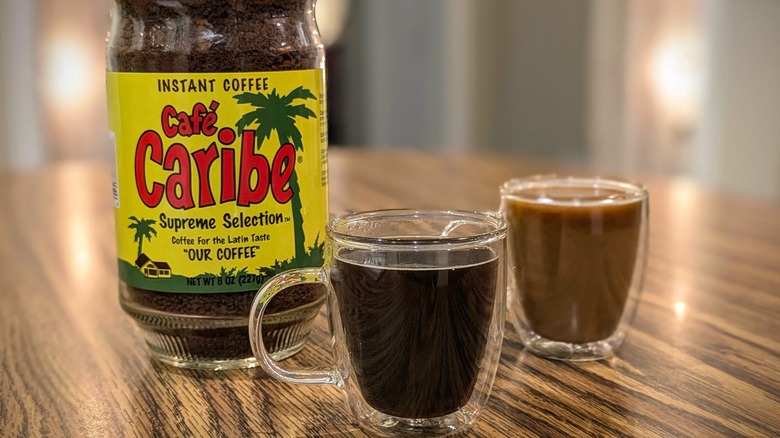 Café Caribe instant espresso jar and two espresso cups on wood table