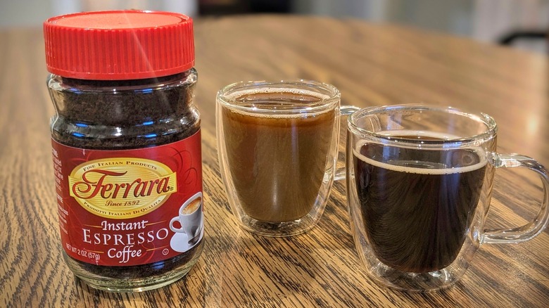 Jar of Ferrara instant esprsso and two espresso cups on wooden table