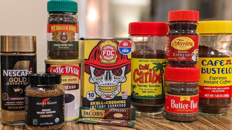 Jars and boxes of different instant espressos stacked on table