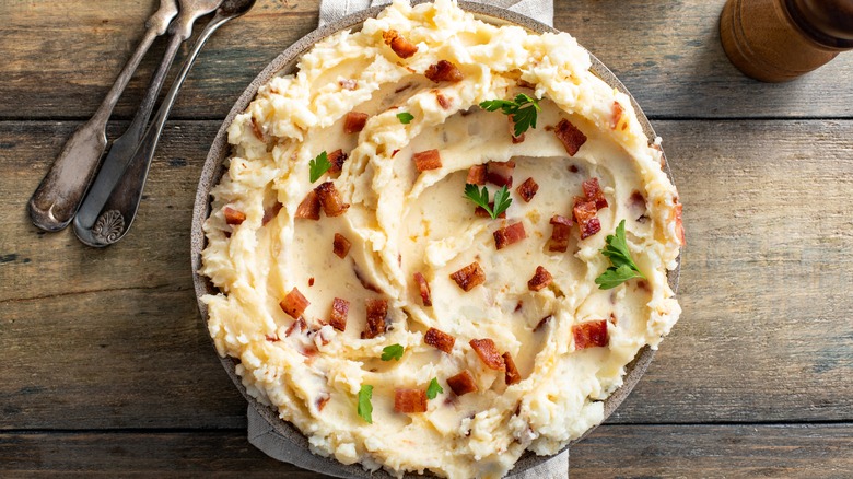 Bowl of mashed potatoes topped with bacon