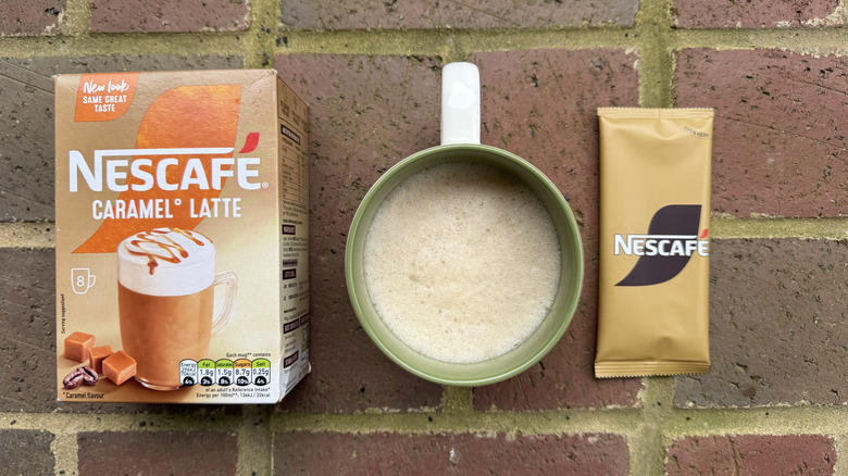 Mug of Nescafé Gold caramel latte with box and stick