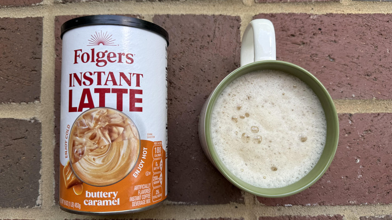 Mug of Folger's buttery caramel latte with cylindrical container