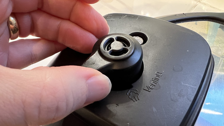 closeup hand adjusting venting knob on instant pot