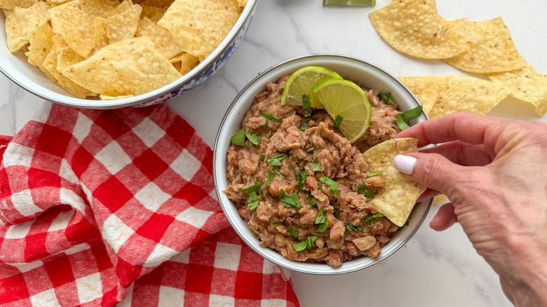 hand dipping chip into dip