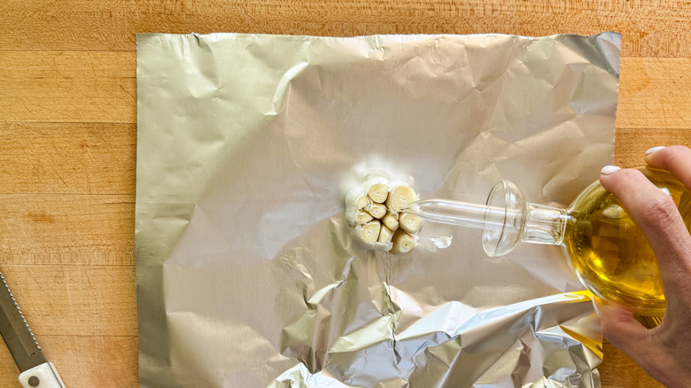 adding oil to garlic bulb