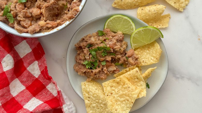 plate with refried bean dip, chips, and lime wedges