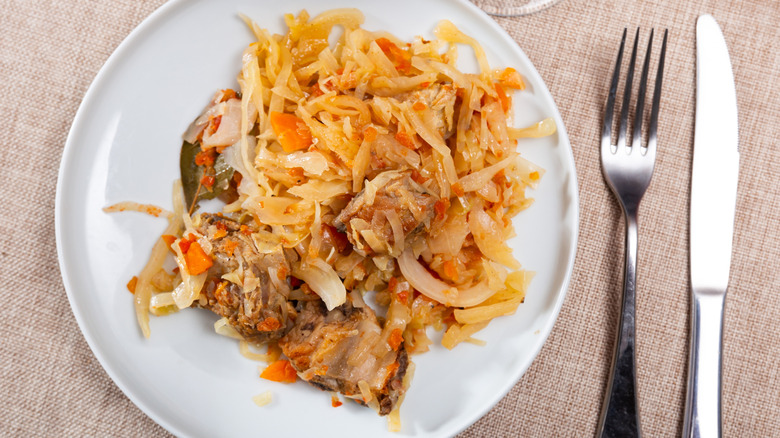 Overhead view of plate of ribs with sauerkraut and carrots on a plate.