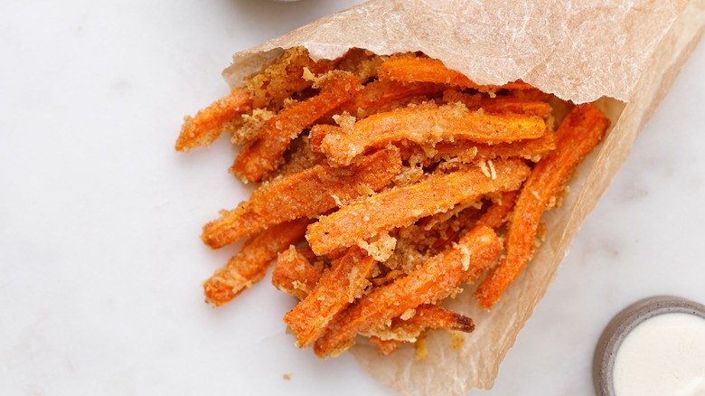 carrot fries in a paper bag with dipping sauce