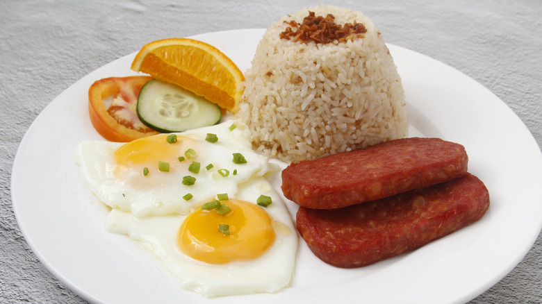 Spamsilog on white plate with orange and vegetable slices