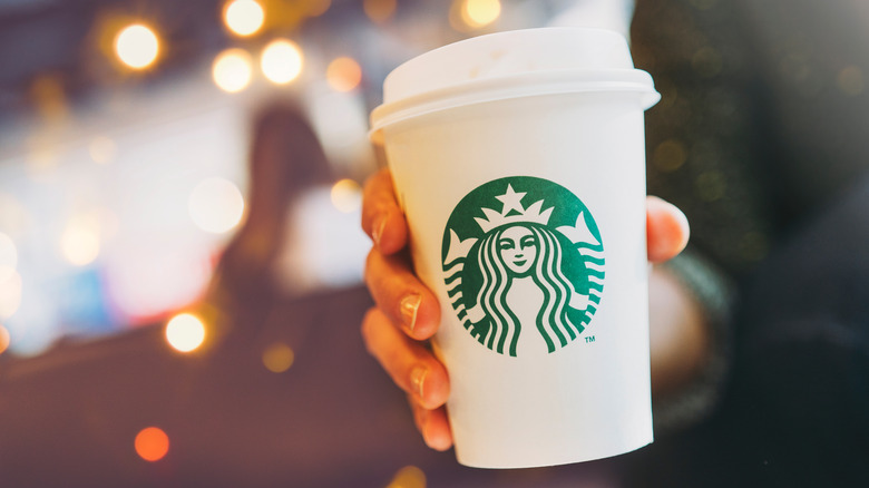 Hand holds Starbucks cup