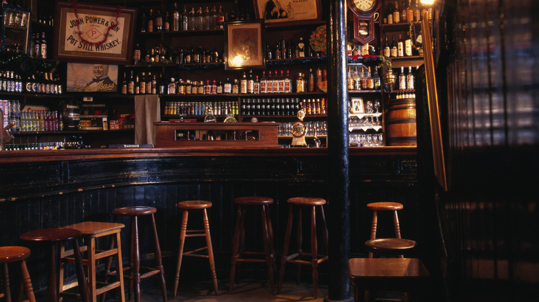 Interior of the pub and grocery at Abbeyleix with bar, stools, and bottles on shelves