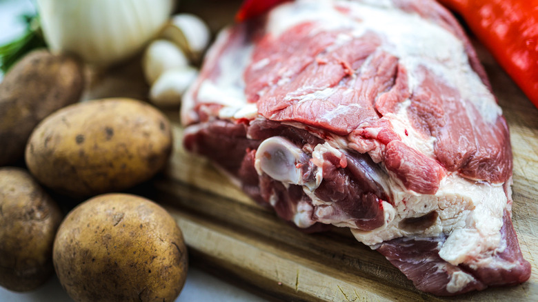 Close-up of raw lamb and potatoes on cutting board