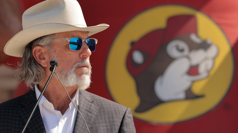 Buc-ee's owner Arch Beaver Aplin III beside the Buc-ee's logo