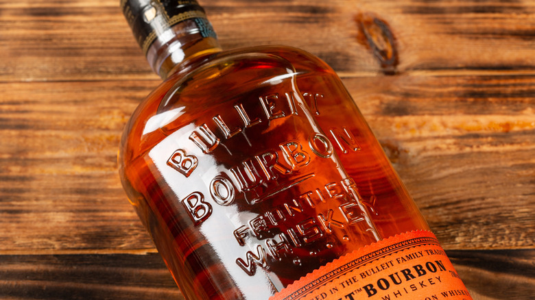 Bulleit bourbon bottle laying on a wooden background
