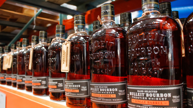 Bulleit bourbon bottles on shelves.