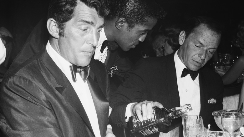 Frank Sinatra pours Jack Daniels in front of Sammy Davis and Dean
