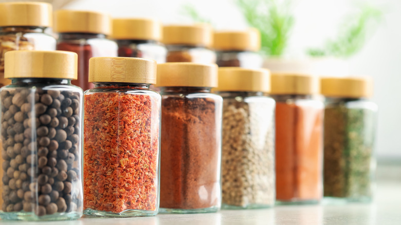 Close-up of different spices in glass bottles on a shelf