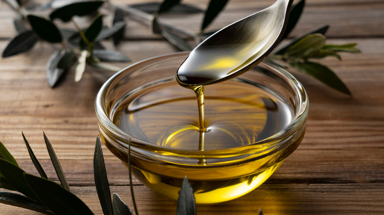 spoon drizzling herb cooking oil