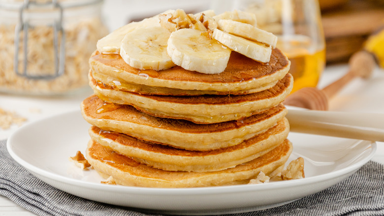 stack of pancakes topped with banana