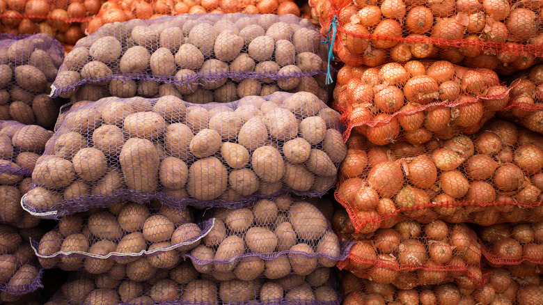 Stacks of potatoes and onions in mesh bags