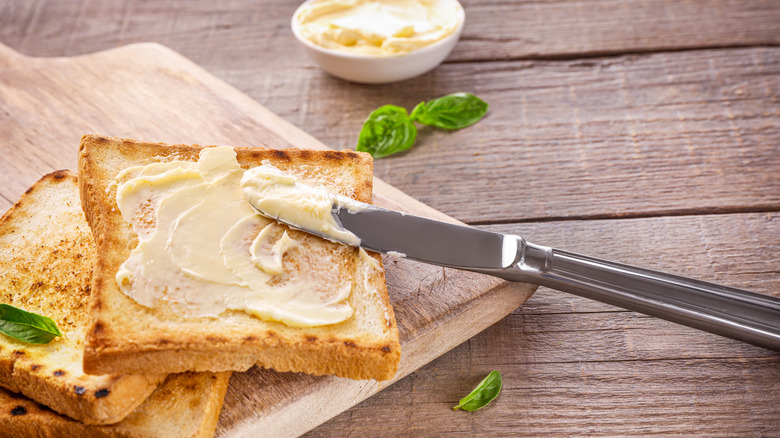 knife spreading butter on toast