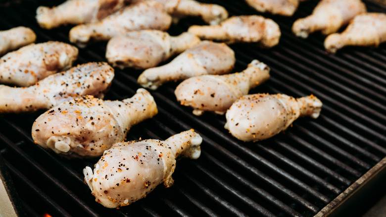 partially cooked chicken drumsticks on grill
