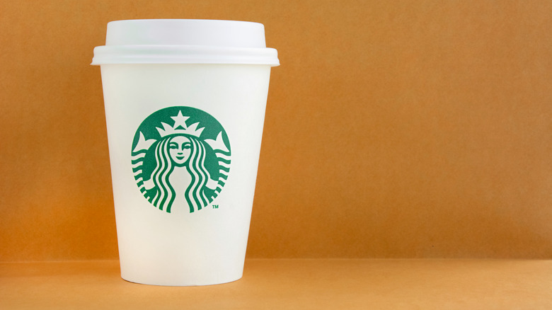 A Starbucks cup against an orange background