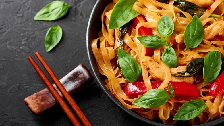 Thai drunken noodles pad kee mao garnished with basil