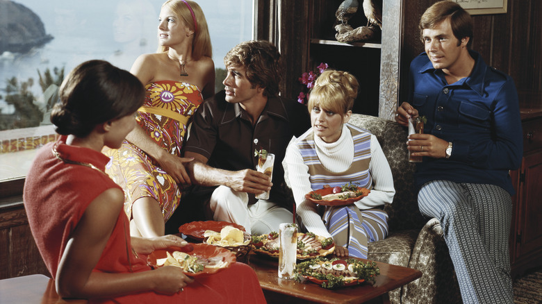 Partygoers enjoying appetizers in the 1970s