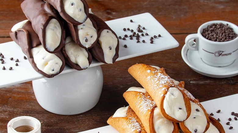 Cannoli on platters next to cup of chocolate chips