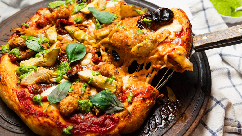 Lifting a slice of pizza with cheese pull from pizza