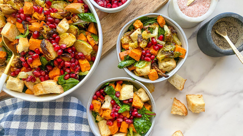 Sweet potato and pomegranate panzanella salad served into white bowls