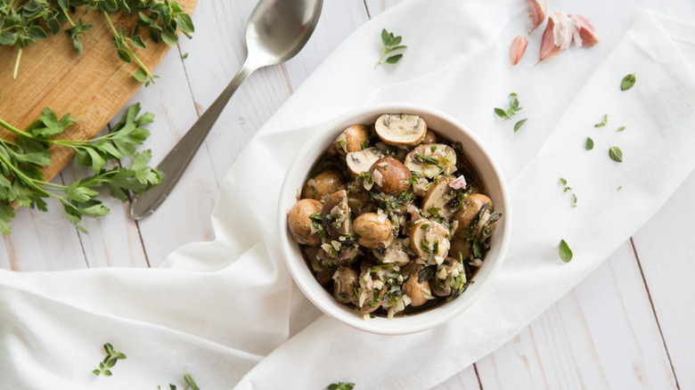 Bowl of marinated mushroom salad with fresh parsley