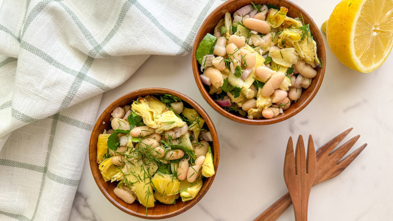 Artichoke and white bean salad in two wooden bowls