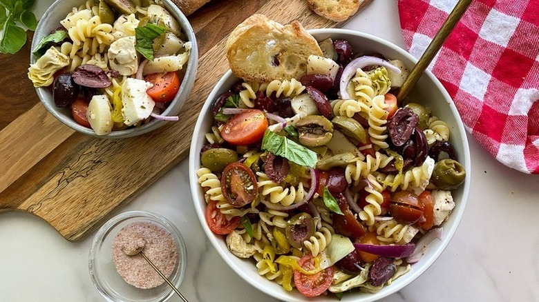 Antipasti pasta salad in white bowls with crostini