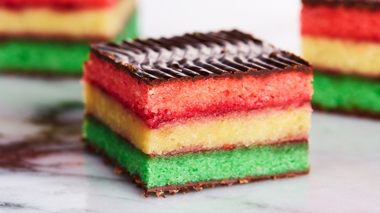 Close up of layered Italian rainbow cookie with chocolate topping