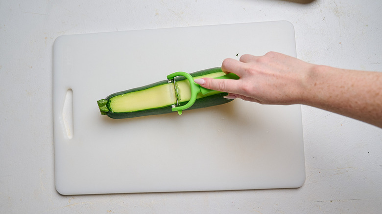 slicing zucchini with a peeler