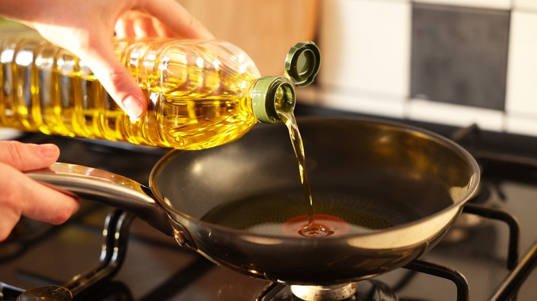 pouring cooking oil into frying pan