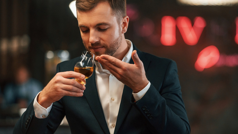 A man nosing a glass of bourbon during a tasting