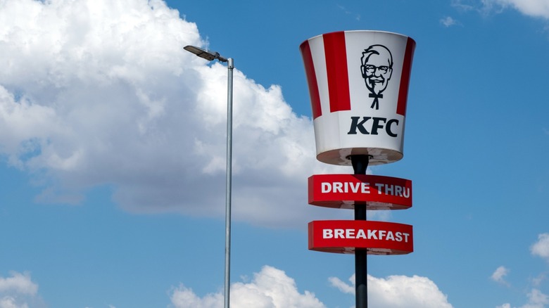 a bucket-shaped KFC sign on a pole