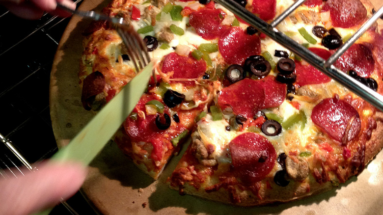 A DiGorno pizza is sliced up on an oven rack