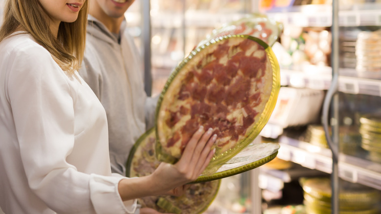 person shopping for frozen pizza