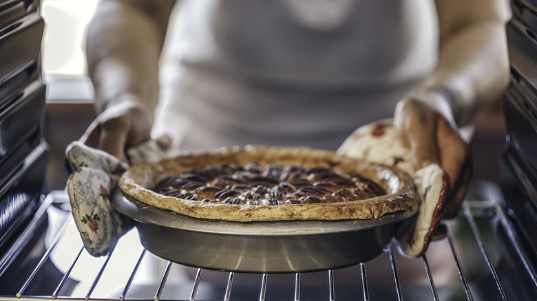 chef removing pie from oven